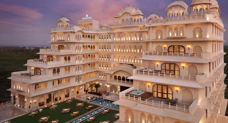 Exterior of Anantara Jewel Bagh Jaipur, with domed terraces and illuminated palace-style façades at dusk.