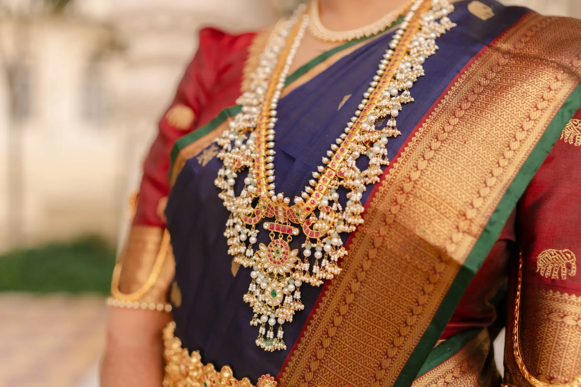 Traditional gold bridal jewellery against a blue and gold silk saree at Hyatt Regency Jaipur Mansarovar, Jaipur