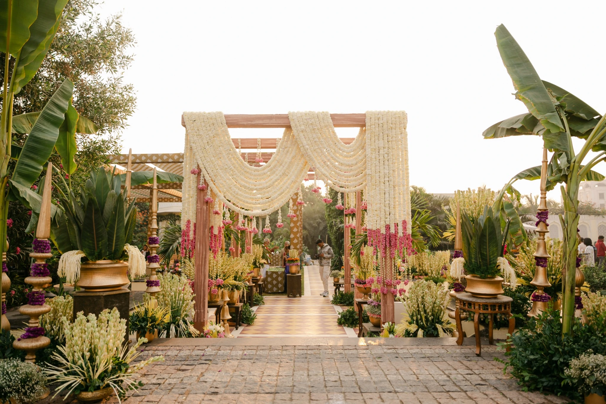 Wedding entrance framed by white garlands and banana plants at Hyatt Regency Jaipur Mansarovar, Jaipur