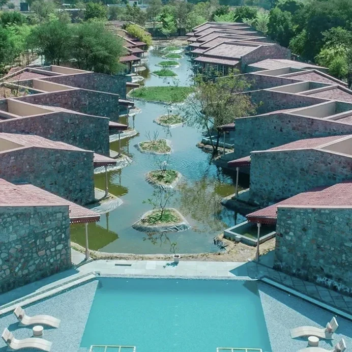 Villa buildings and pools arranged along a landscaped waterway at Brij Bageecha.