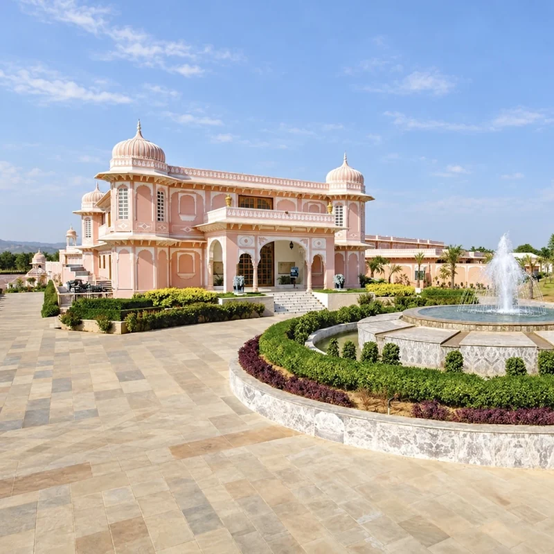 Pink resort façade and circular fountain at Buena Vista Luxury Garden Spa Resort, Jaipur.
