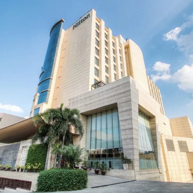 High-rise hotel façade photographed from the entrance at Hilton Jaipur.