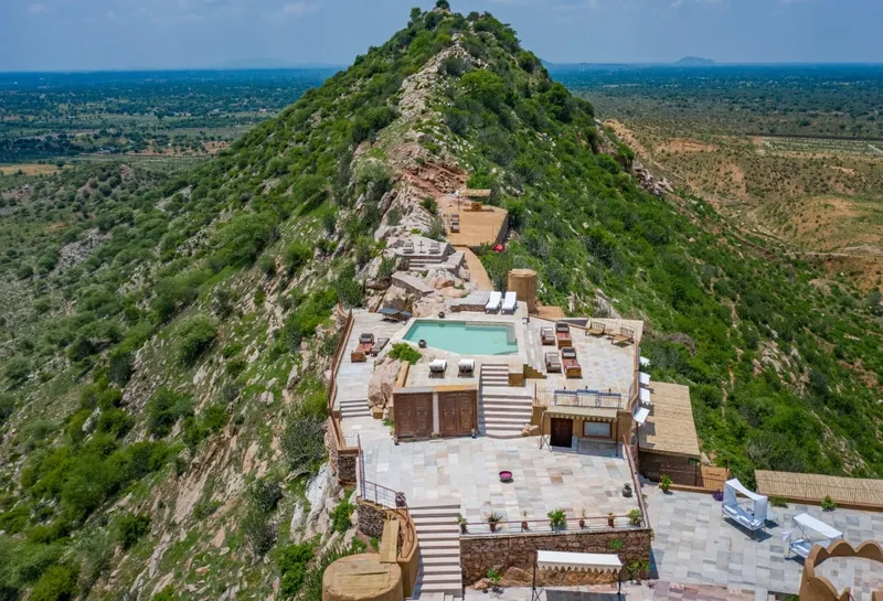 Mundota hilltop fort and pool terrace with the green ridgeline behind.