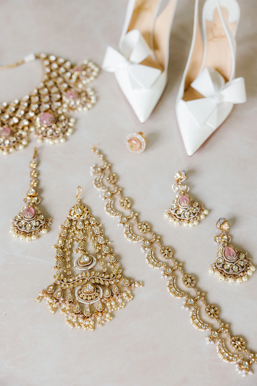 Bridal jewellery and white shoes arranged before the celebration