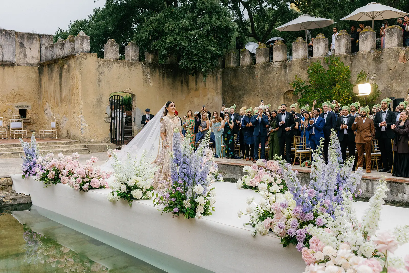 Bride and groom during the courtyard ceremony with family and guests gathered behind them