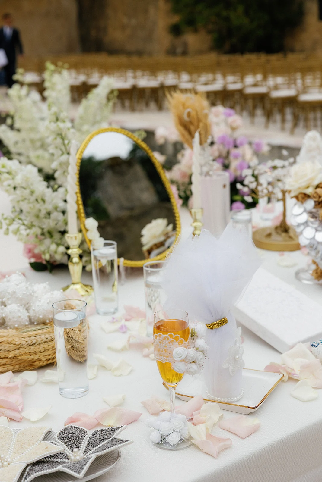 Wedding table setting with pastel pink, ivory and lilac flowers and gold-toned accents.