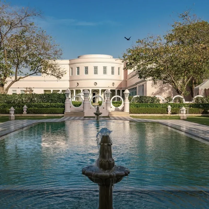 Palace façade beyond a reflecting pool and fountain at Rajmahal Palace RAAS.
