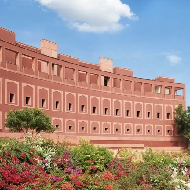 Terracotta-coloured resort façade and landscaped gardens at Devi Ratn, Jaipur.