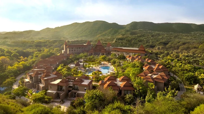 Wide view of The Westin Jaipur resort buildings, grounds and surrounding hills.